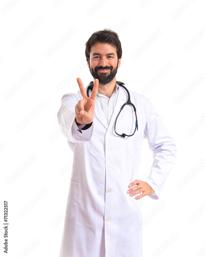Doctor doing victory gesture over white background Doctor doing victory gesture over white background