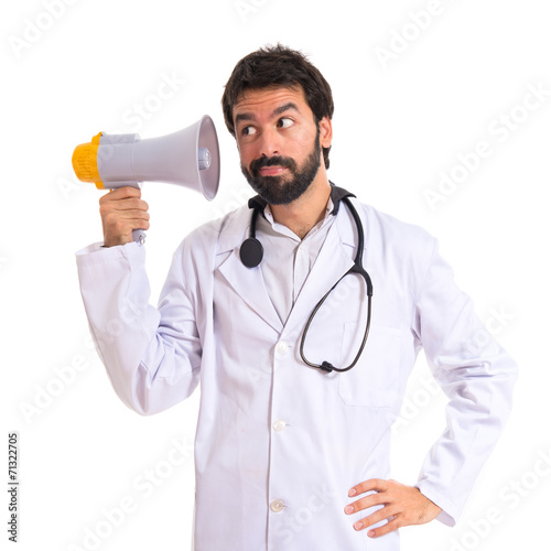 Doctor listening by megaphone over white background