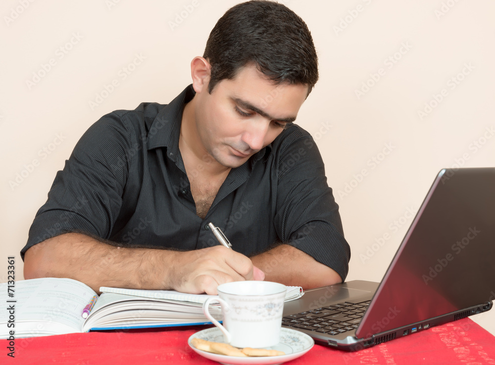 Hispanic man studying or doing office work at home Hispanic man studying or doing office work at home
