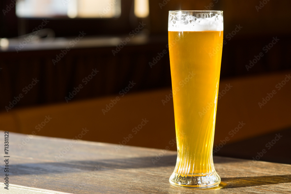 Sunlit Glass of Beer on Table
