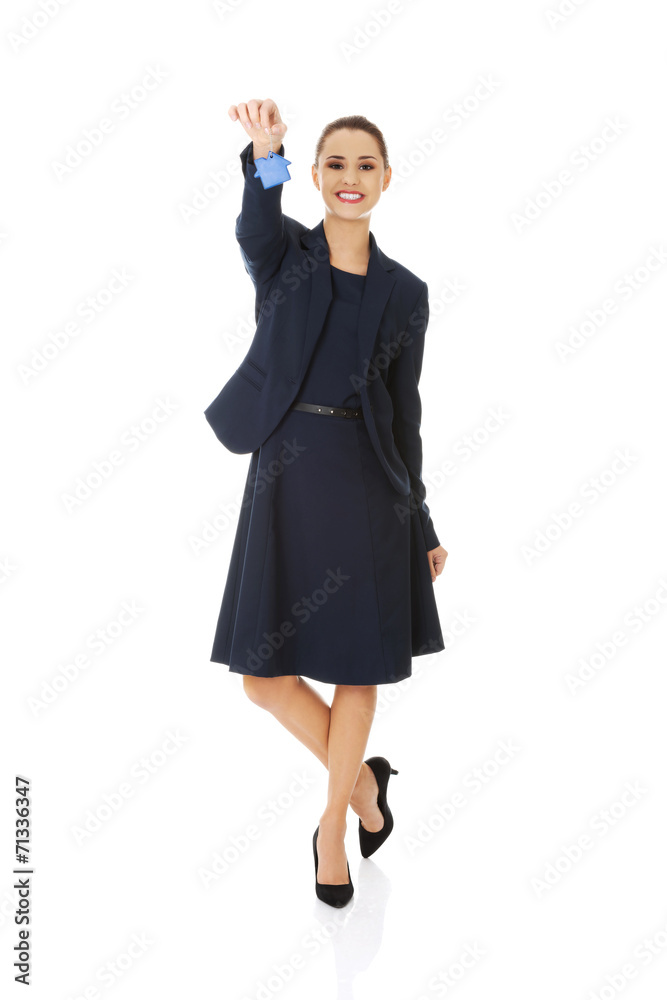 Happy real estate agent, holding a house key Happy real estate agent, holding a house key
