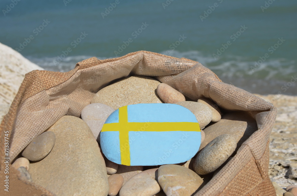 Swedish flag on a stone in a bag with pebbles