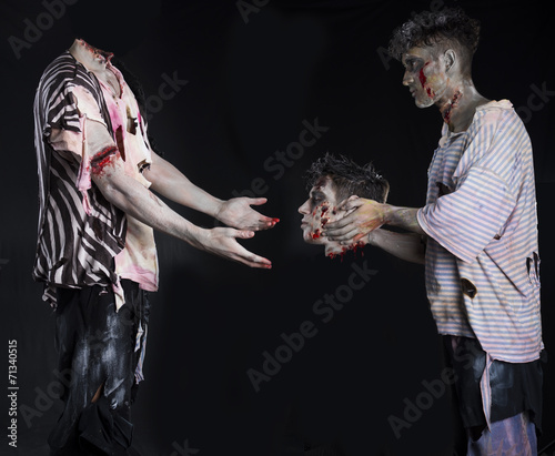 Two zombies, one giving the head to the decapitated one's body