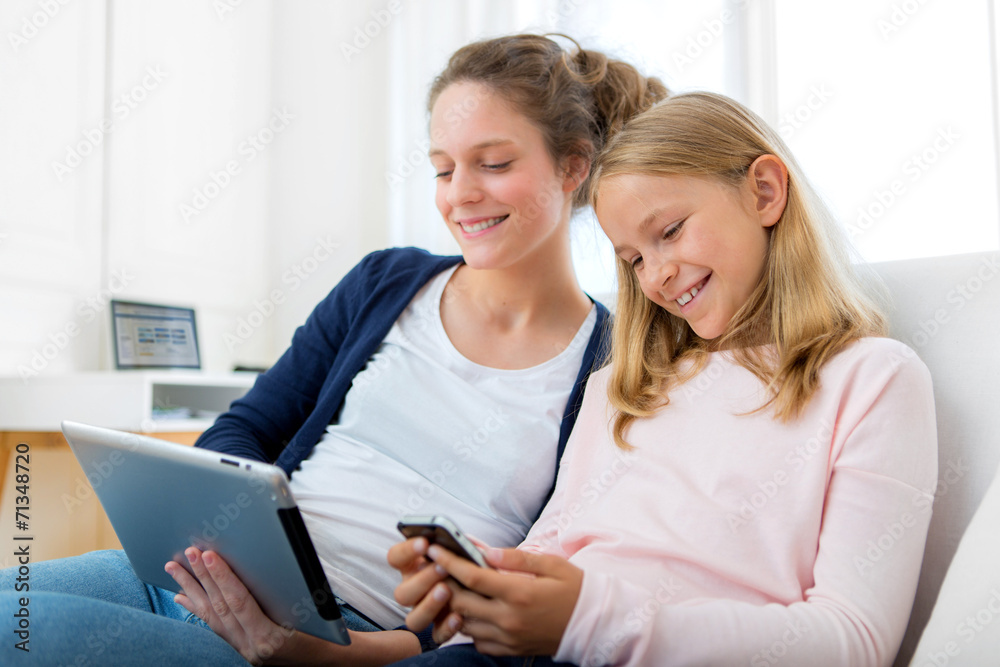 Attractive woman and little sister using tablet