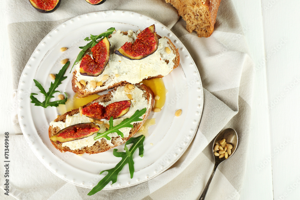 Tasty sandwiches with sweet figs and cottage cheese on plate