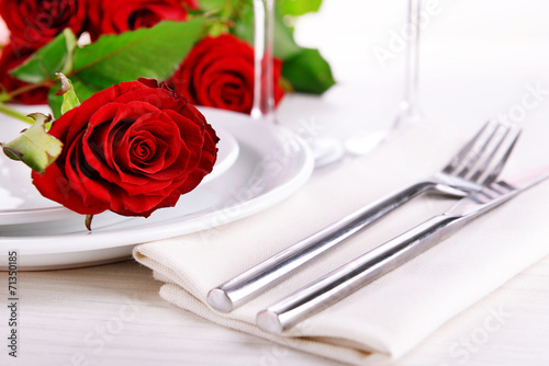 Table setting with red rose on plate