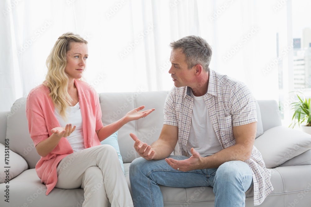 Unhappy couple having an argument on the couch Unhappy couple having an argument on the couch