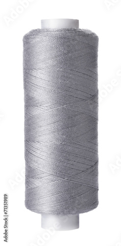 Single reel of gray thread on white background