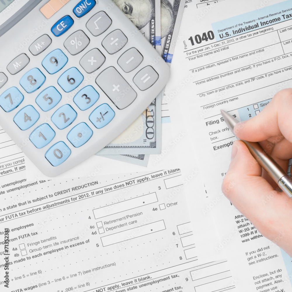 Man filling out 1040 US Tax Form - view from top - 1 to 1 ratio