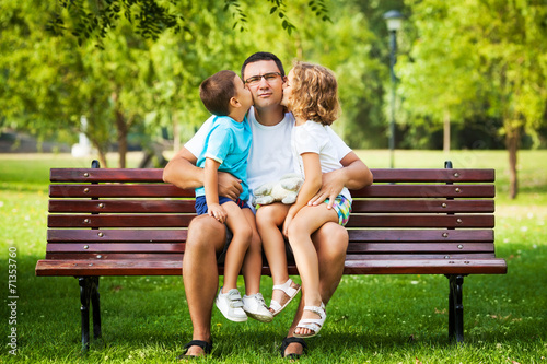 Father enjoying a tender kisses from his little children