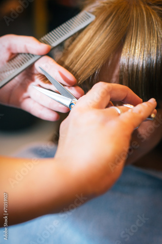 Woman at the beauty salon straightening hair