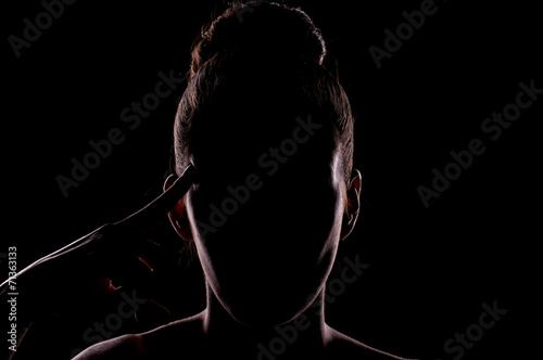 portrait of woman touching temple with the face in shadow