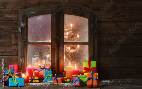 Gift Boxes and Candles at Window on Christmas