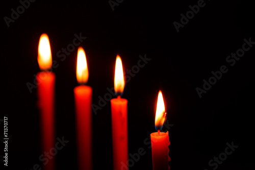 four candles on black background
