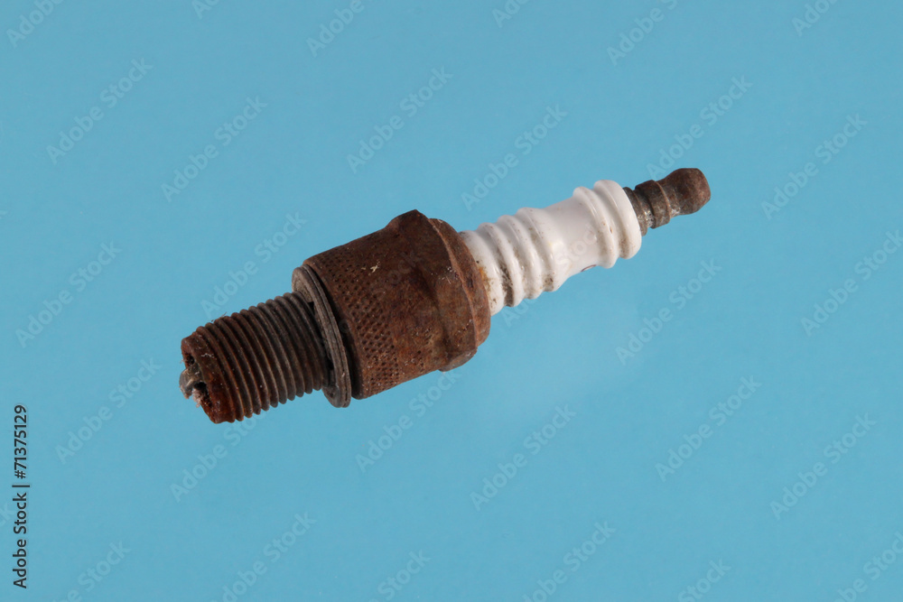 Old spark plug on a blue background. Old spark plug on a blue background.