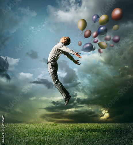 Man jumping up to Sky wit color bright balloon © Soloviova Liudmyla