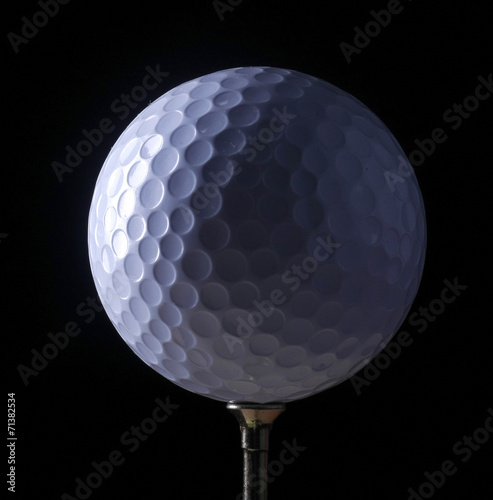 A close-up of a golf ball over dark background