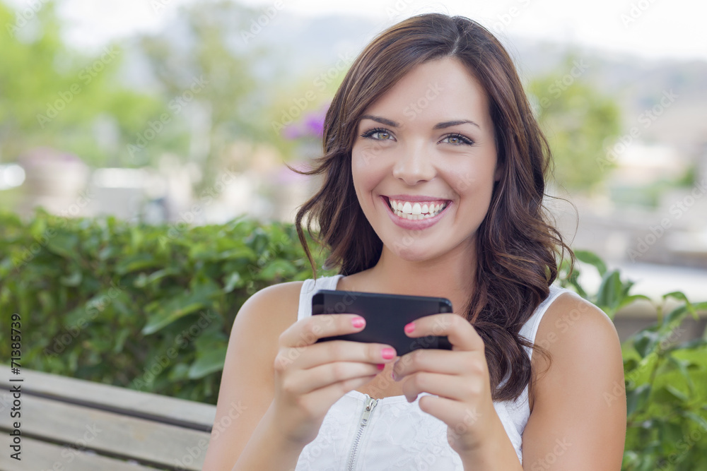 Smiling Young Adult Female Texting on Cell Phone Outdoors Smiling Young Adult Female Texting on Cell Phone Outdoors