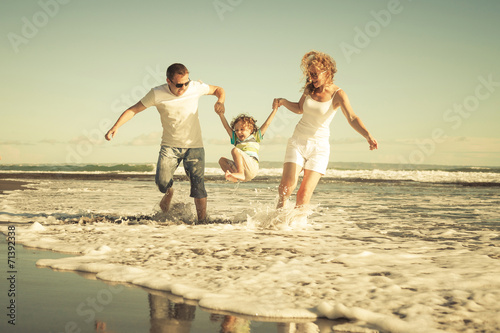 Happy family playing on the beach at the day time