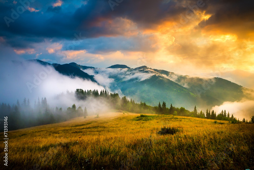 Fototapeta Naklejka Na Ścianę i Meble -  Amazing mountain landscape with fog and a haystack