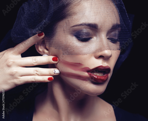 beauty brunette woman under black veil with red manicure close