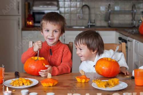 Two adorable boys, preparing jack o lantern for Halloween