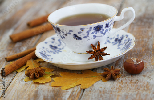 Cup of tea, star anise, cinnamon, autumn leaves and chestnuts