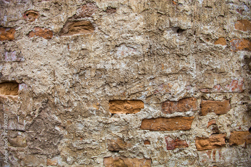 Partly plastered brick wall with rich texture