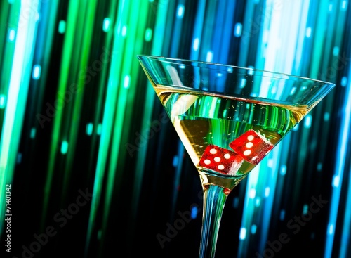 Photography red dice in the cocktail glass on colorful gradient