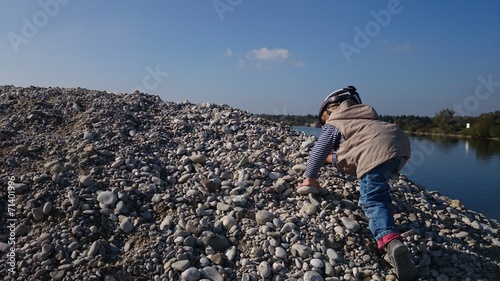 Junge klettert auf steinen bei see photo