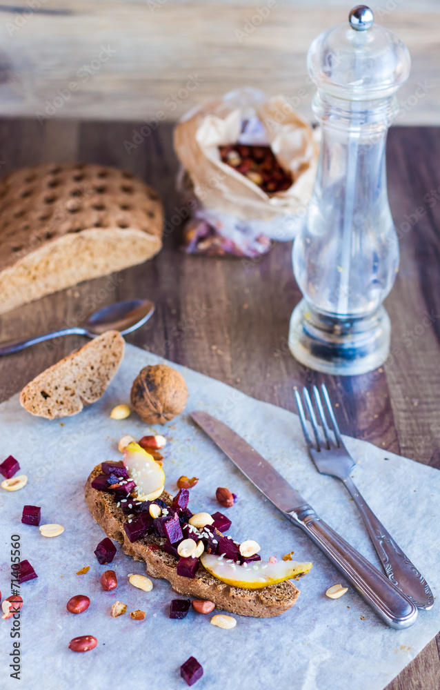 sandwich with beets, walnuts and pear on black bread