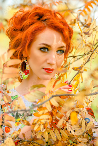 Fototapeta Naklejka Na Ścianę i Meble -   Red-haired girl with yellow leaves