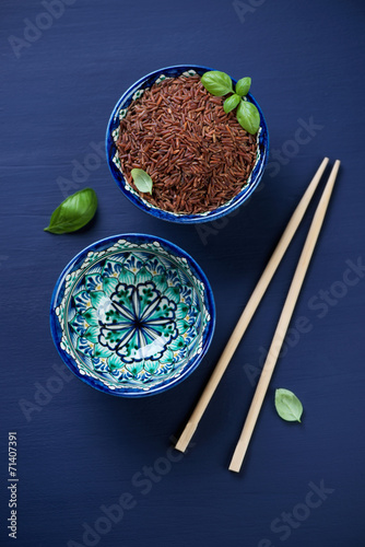 Ceramic tableware with red rice, view from above, vertical shot