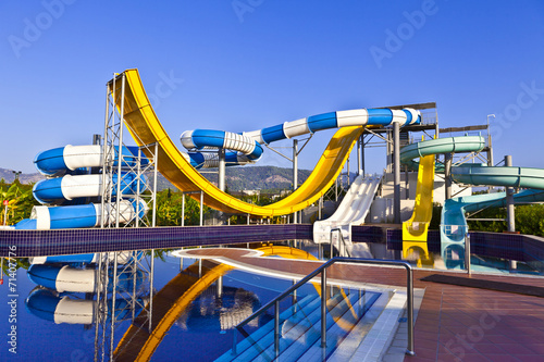 Blue, white and yeloow waterslide in a pool.
