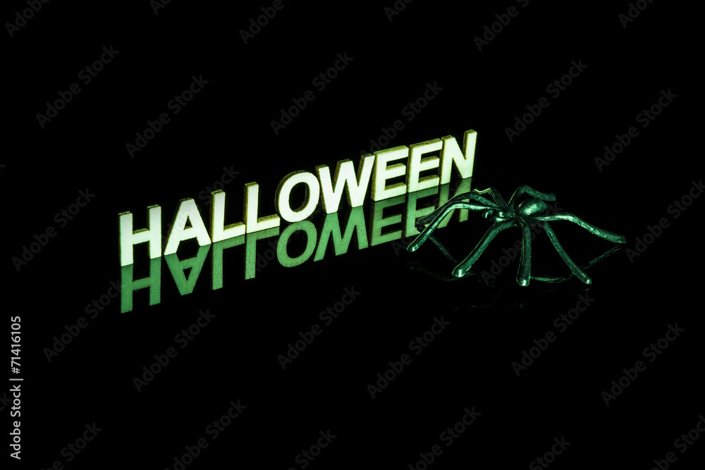 Naklejka premium Halloween word and spider with reflection on black