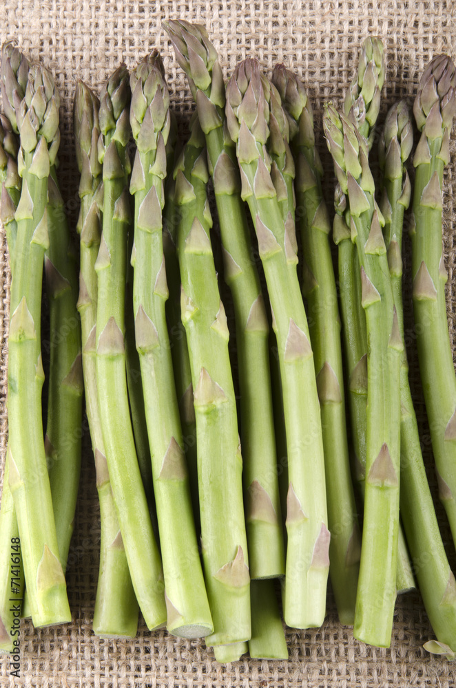 Fototapeta premium green asparagus on jute cloth