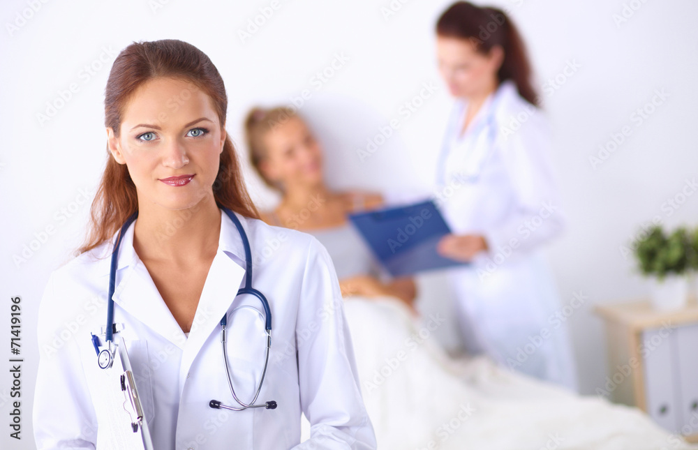 Smiling female doctor with a folder in uniform standing at Smiling female doctor with a folder in uniform standing at