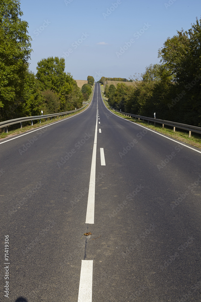 Gerade Straße in hügeliger Landschaft Gerade Straße in hügeliger Landschaft