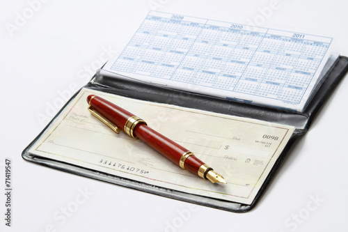 An open checkbook and a ballpen isolated on white