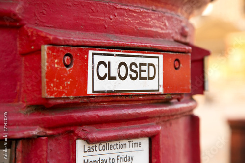 a shut red british letter box. photo