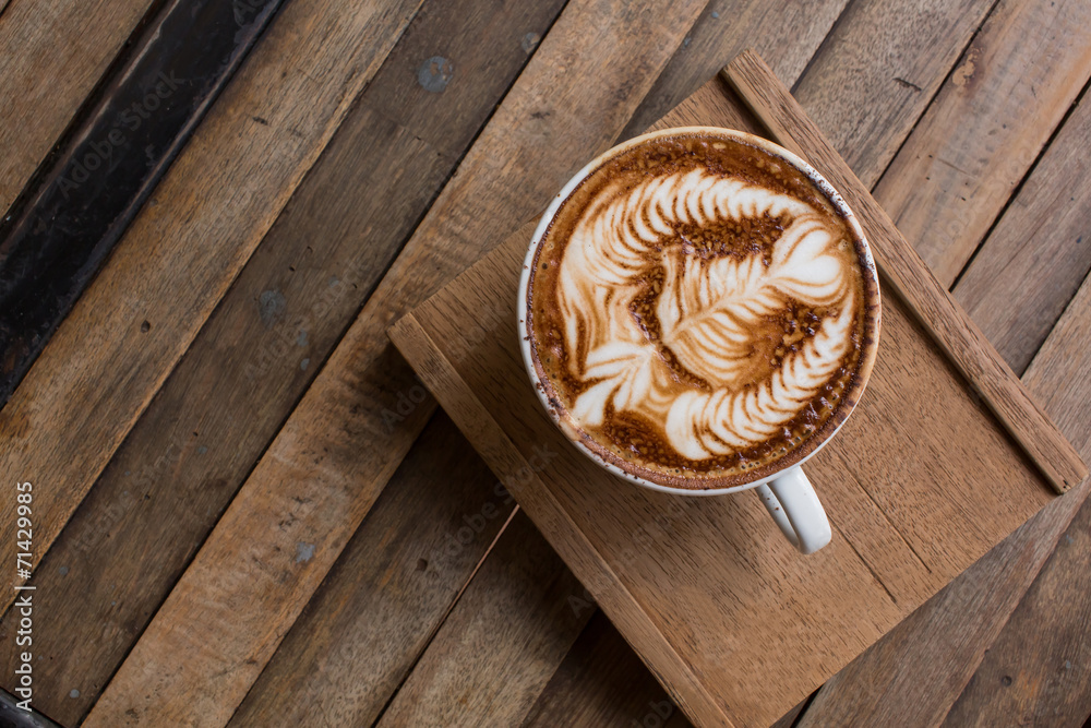 Cup of hot latte art coffee on wooden table Cup of hot latte art coffee on wooden table