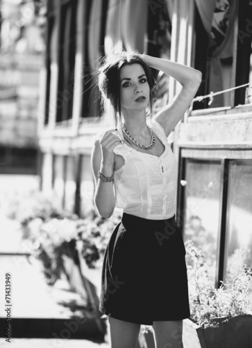 Monochrome portrait of slim woman in skirt on street © Кирилл Рыжов