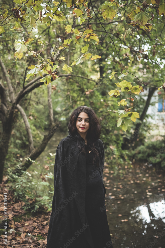 beautiful dark vampire woman with black mantle and hood