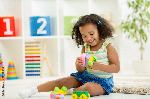 Fototapeta Kid dívka hrát hračky ve školce místnosti