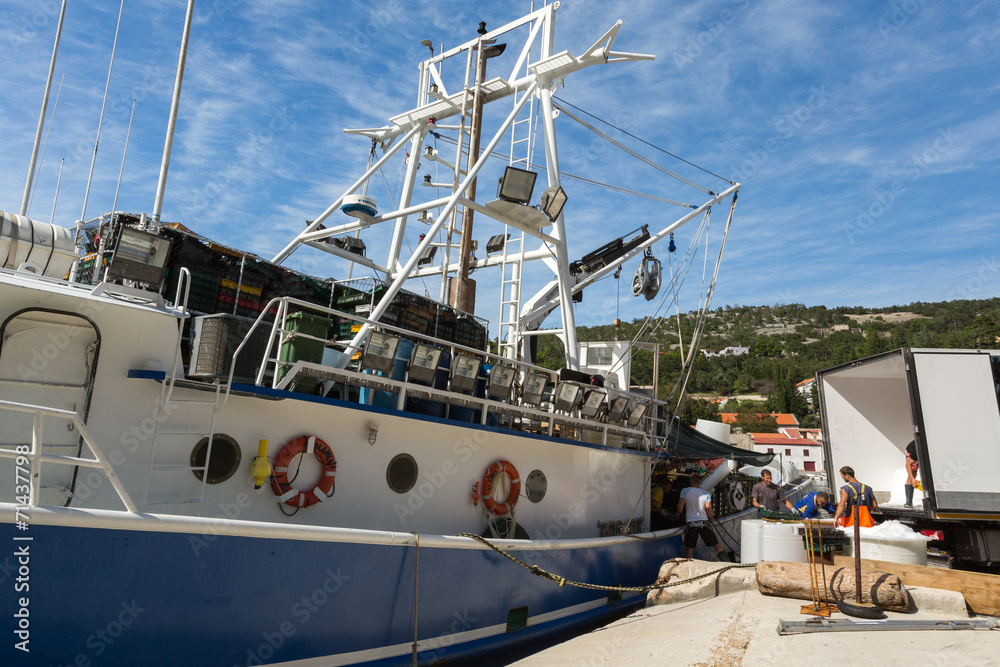 Naklejka premium Déchargement de poisson du bateau de pêche