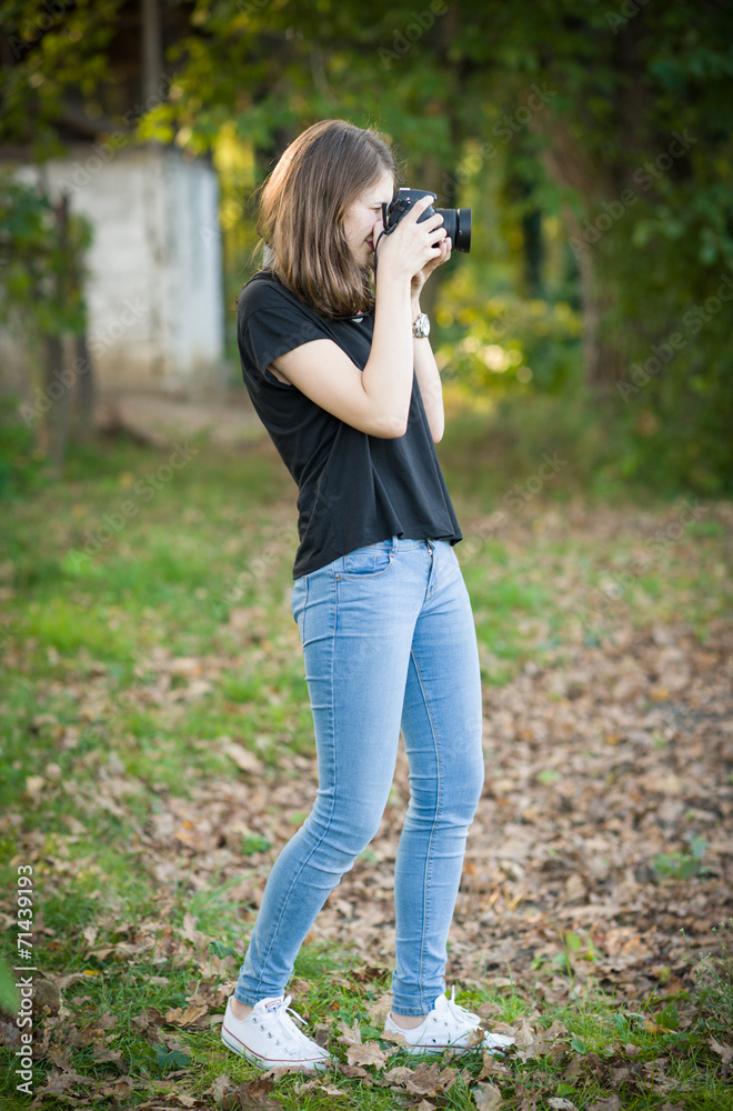 Attractive young girl taking pictures outdoors