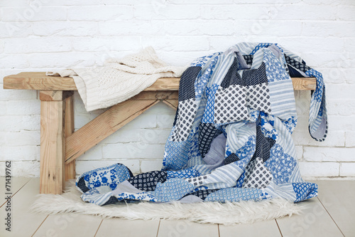 Patchwork quilt on rustic bench photo