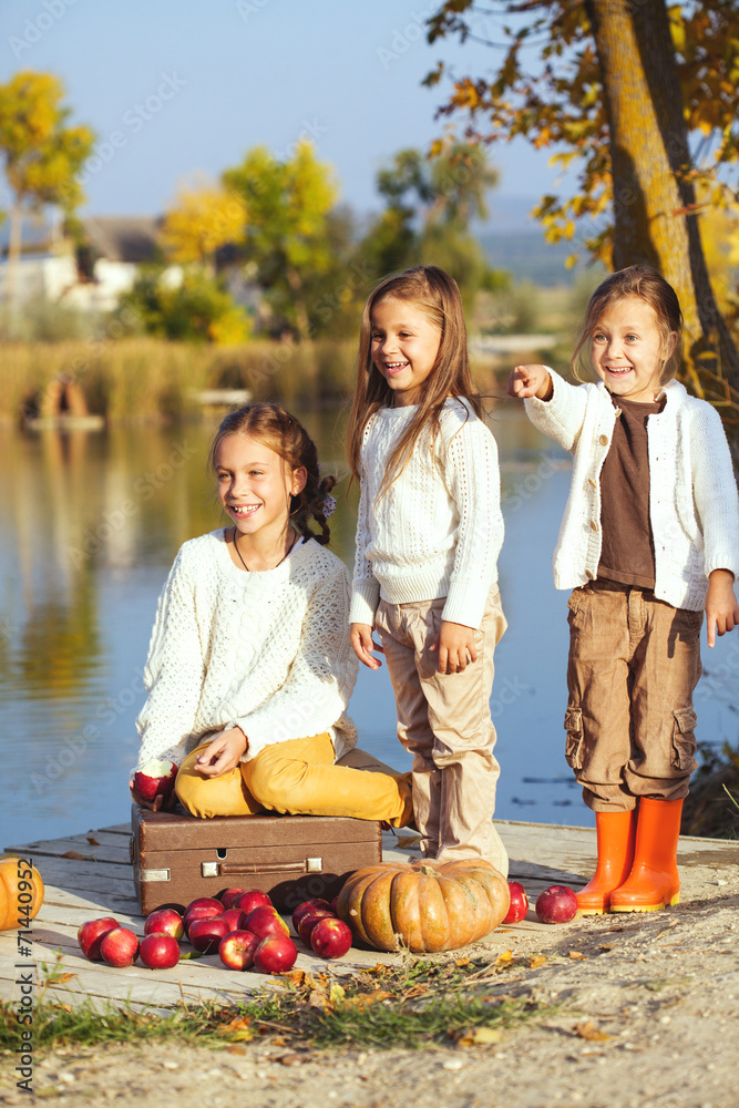 Fototapeta premium Kids playing near the lake in autumn