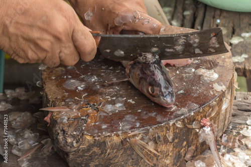 close-up of a worker cutting fish on a board
