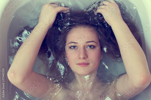 Photography closeup portrait of beautiful blond young woman washing her hair
